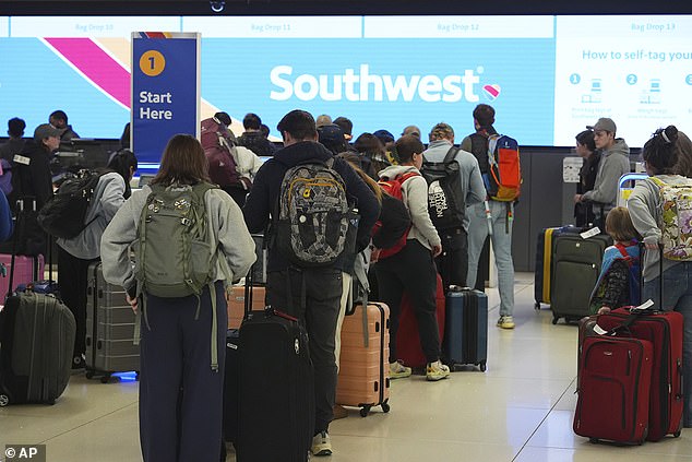 AAA predicted earlier this month that 119.3 million people will travel 50 miles or more between December 21 and January 1, breaking the previous record of 64,000 travelers in 2019 (Photo: Travelers waiting at the Southwest check-in counter at Denver International Airport December 19)