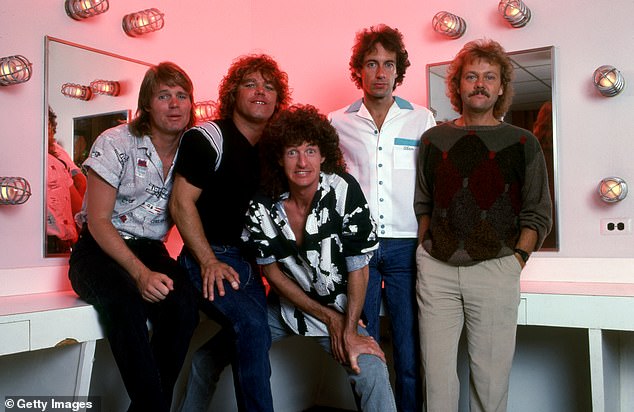 Cronin (center) joined the group as vocalist in 1972. The band had great success in the 1980s with hits such as Keep On Lovin' You and Take It On The Run (pictured, with Bruce Hall, Gary Richrath, Alan Gratzer and Neal Doughty). in Detroit in December 1985)