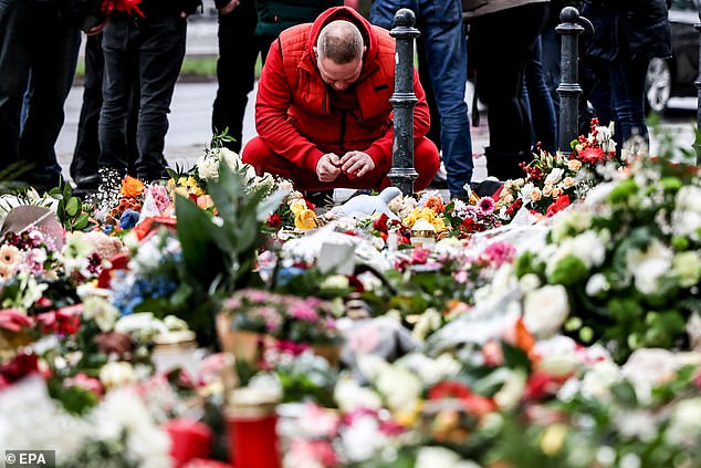 A man cries at the site in memory of the victims of the attack on the Christmas market on Friday