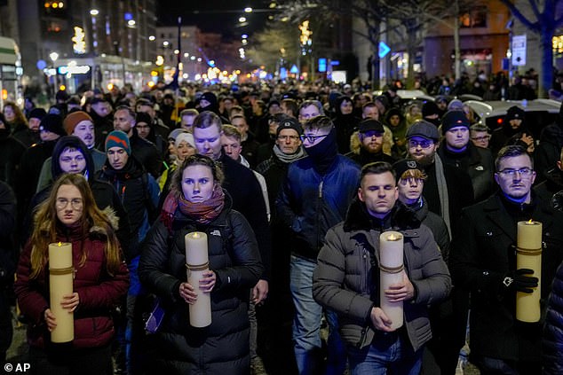 People carry candles during an AfD election campaign in front of Magdeburg Cathedral.