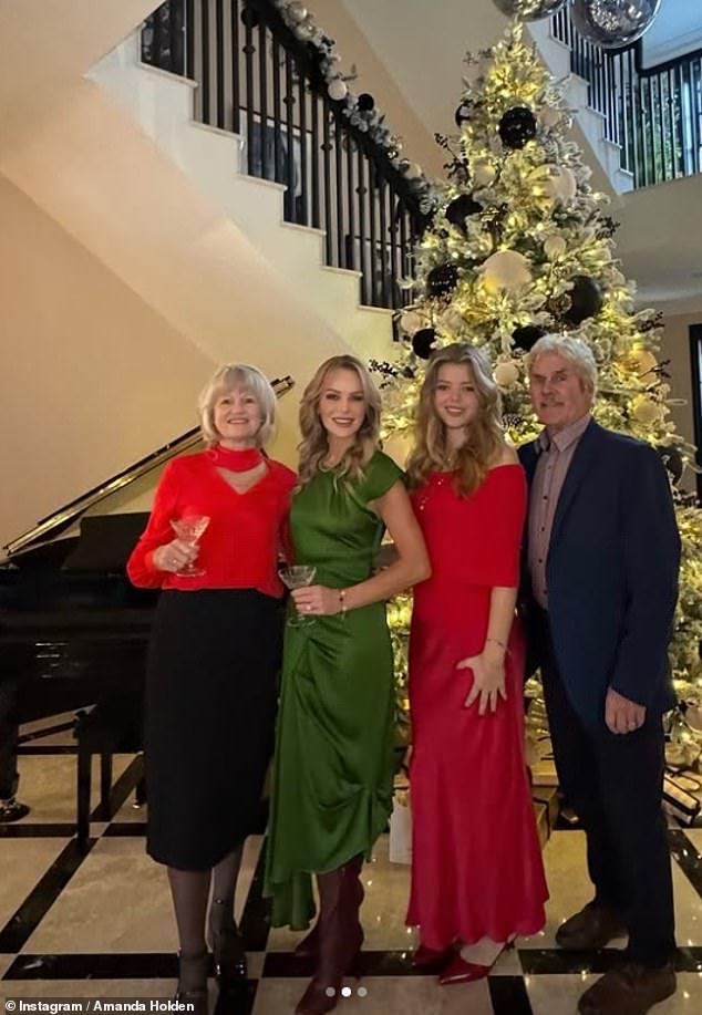 The radio presenter, 53, wowed in a long satin green dress paired with burgundy boots as she posed up a storm in front of her tree.