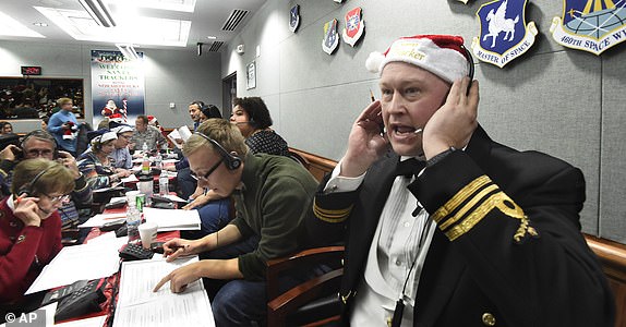 FILE â¿" Canadian Lt. Major Chris Hache receives a call while volunteering at the NORAD Tracks Santa center at Peterson Air Force Base in Colorado Springs, Colorado, Dec. 24, 2017. (Jerilee Bennett/The Gazette via AP, File)