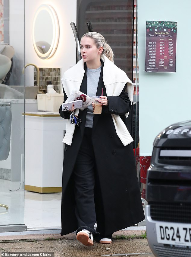 The former Love Island star, 25, looked cozy as she stepped out in a gray t-shirt, underneath a floor-length black trench coat.