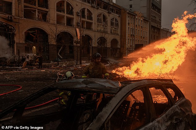 Ukrainian rescuers work to extinguish a fire at the site of a missile attack in kyiv on December 20, 2024.