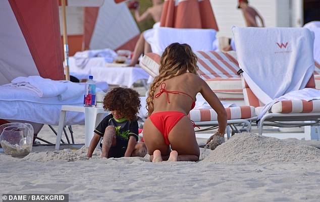 She played in the sand with her son.