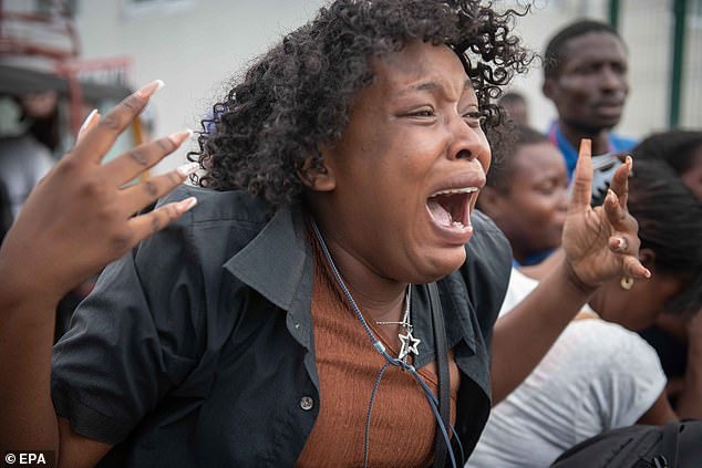 A journalist's wife cries outside La Paixe Hospital in Port-au-Prince, Haiti