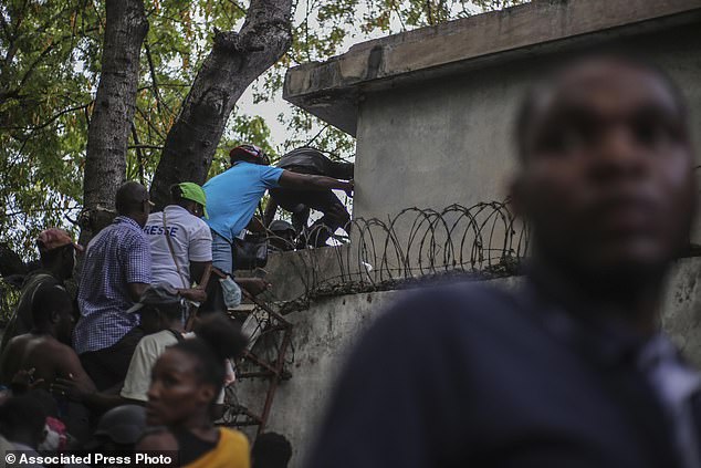 Journalists climb a wall to take cover from gunfire after being shot at by armed gangs