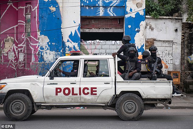 Police officers patrol a street after the attack on the public hospital in Port-au-Prince