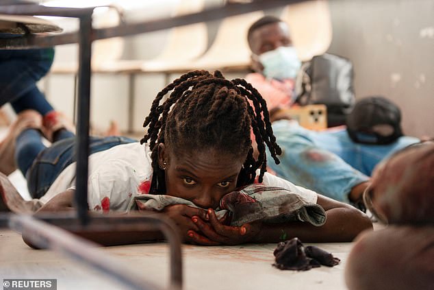 An injured woman looks on after gunmen opened fire on a group of journalists