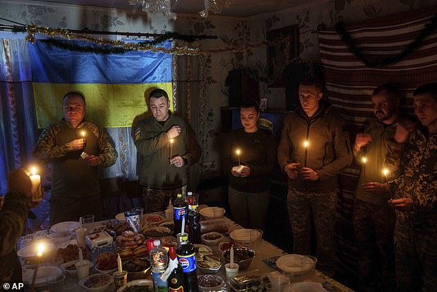 Ukrainian servicemen from the 117th Independent Heavy Mechanized Brigade pray before a Christmas dinner heading to Pokrovsk on December 24.