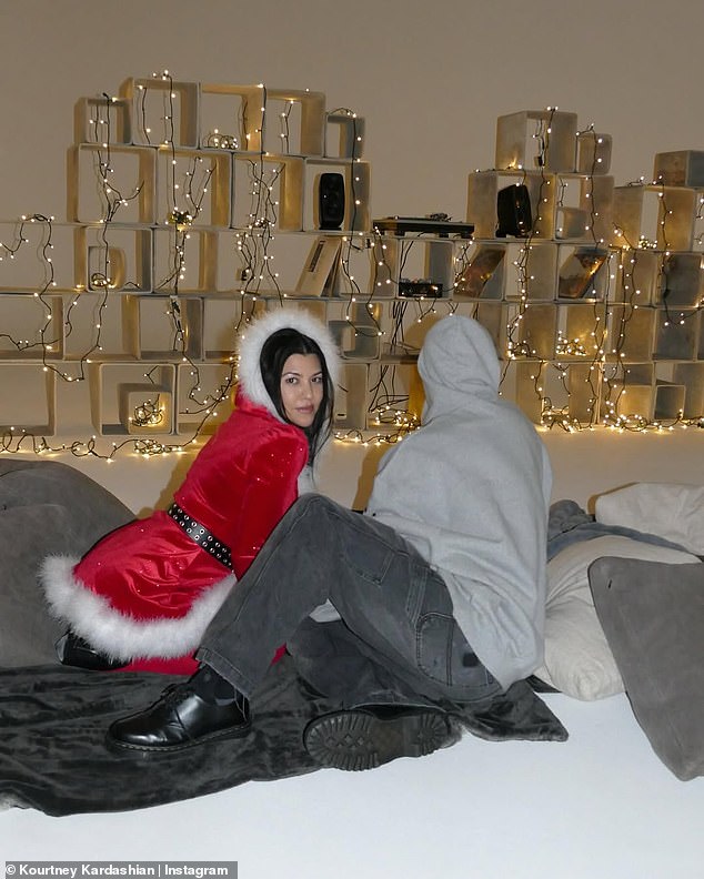 Travis kept things relaxed in a gray graphic hoodie and dark gray jeans.