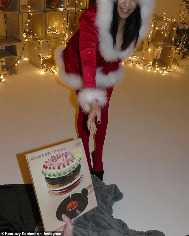 Travis could be seen handing a copy of the Rolling Stones' iconic 1969 LP, Let It Bleed, to Kourtney.