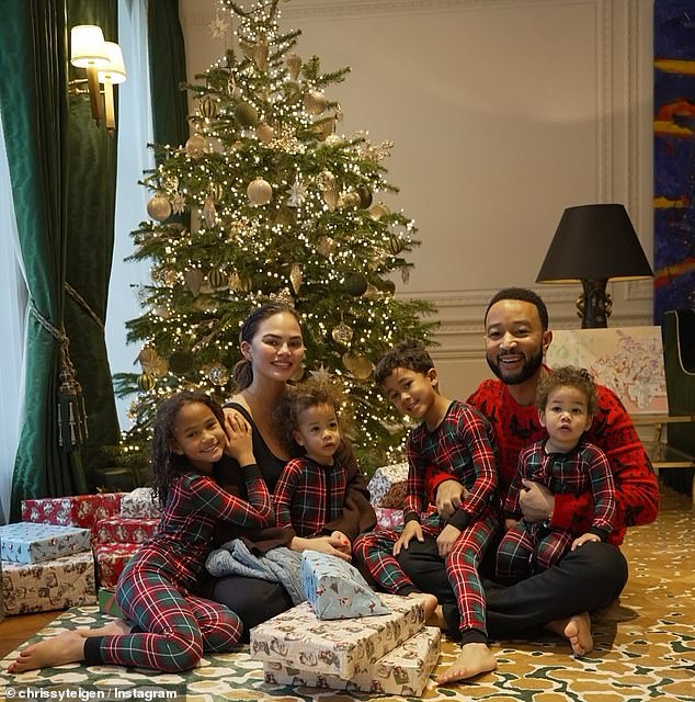 John Legend and Chrissy Teigen gathered around the tree on Christmas morning with their children Luna, eight, Miles, six, Esti, one, and Wren, one.