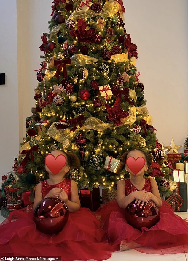 In other images, the family posed sitting in front of the tree smiling happily, while the singer covered the little ones' faces with a red heart emoji.