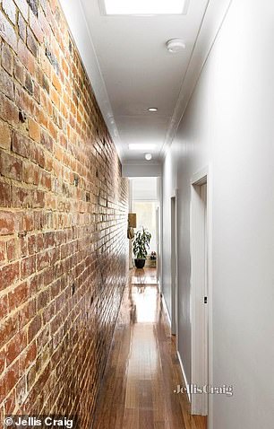 A standout feature is the exposed brick wall, which adds a rustic touch and runs like a visual thread throughout the property.