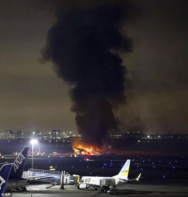 A tower of smoke billowed from the burning wreckage of the plane at Haneda Airport