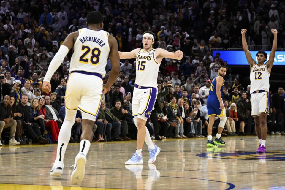 Lakers guard Austin Reaves celebrates with teammates Rui Hachimura and Max Christie against the Warriors.