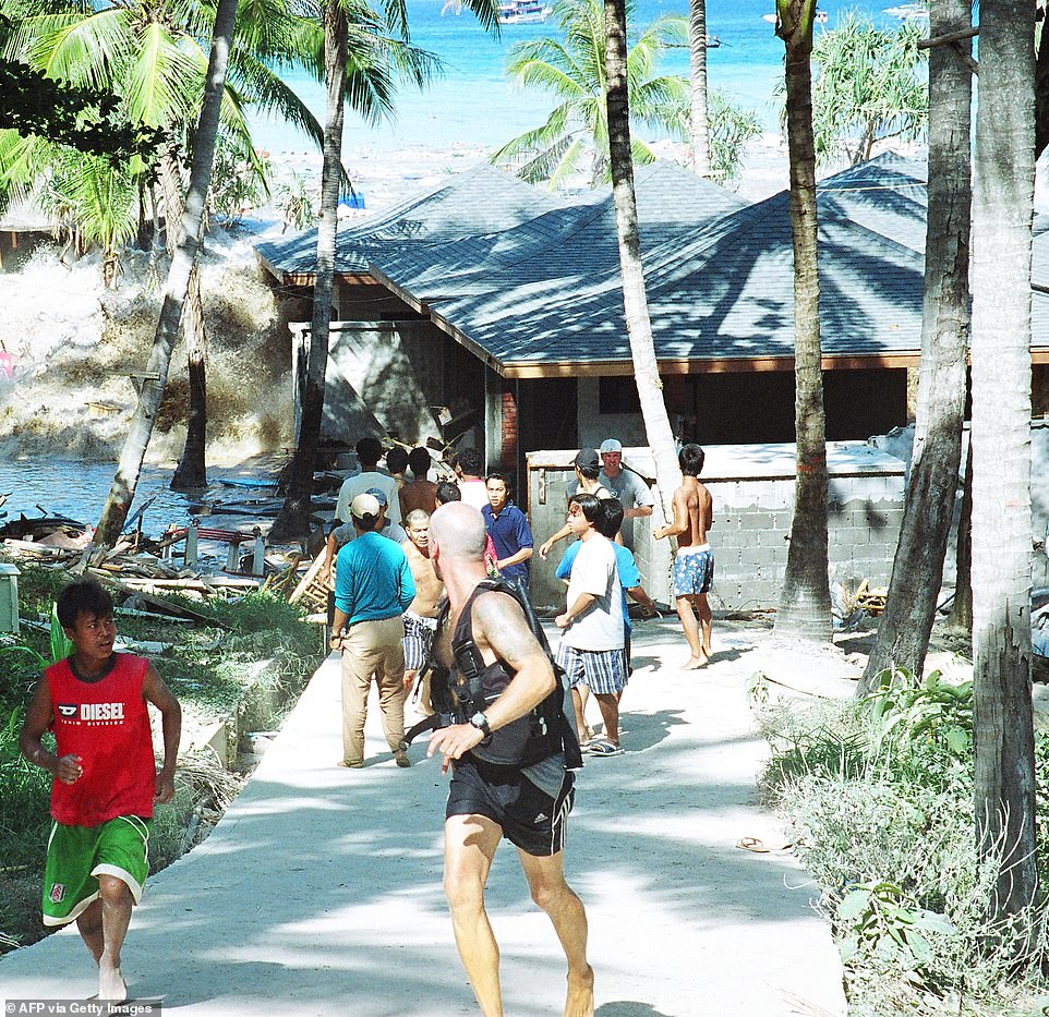 This photo taken on December 26, 2004 shows people fleeing as a tsunami makes landfall at Koh Raya, Thailand