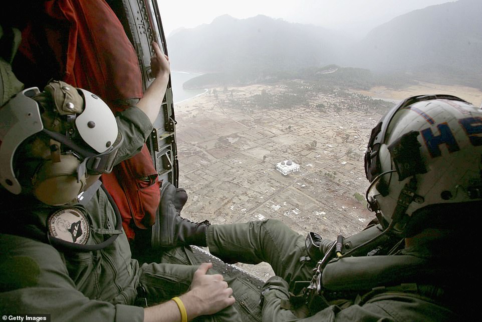 The crew of a US Navy Seahawk helicopter from aircraft carrier USS Abraham Lincoln observes the devastation caused by the Indian Ocean tsunami on January 8, 2005, Aceh, Indonesia