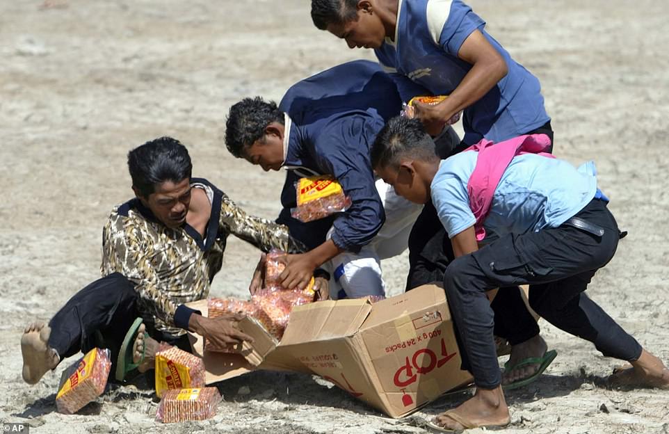 Displaced Indonesians struggle for relief food delivered by a US military helicopter at a UN refugee camp south of Panga in Aceh province, Sumatra island on Thursday, January 20, 2005