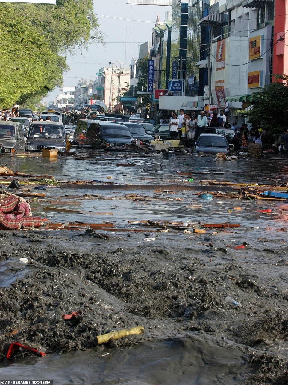 A street in Banda Aceh, Aceh province, Indonesia is flooded with water, mud and debris in the minutes after the tsunami washed over the city