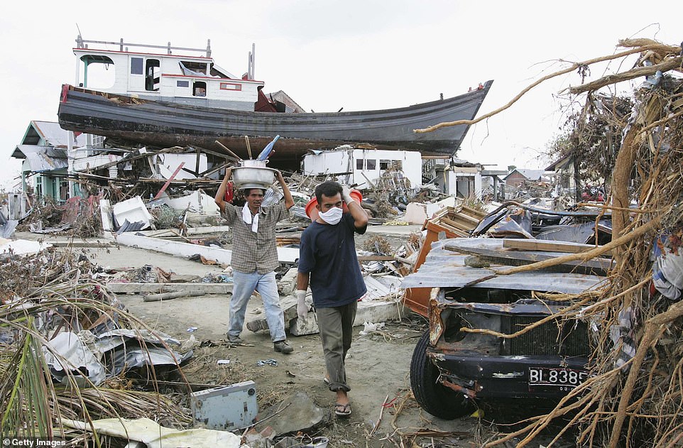 People displaced by the tsunamis walk through their devastated neighborhood in Banda Aceh, Indonesia on January 4, 2005