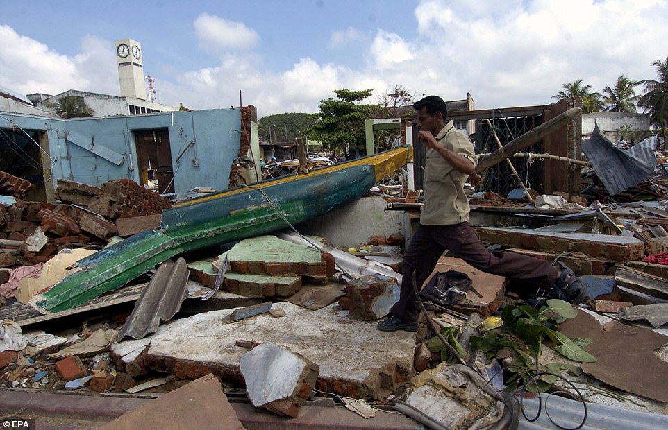 A man walks over the rubble of houses destroyed by tsunami waves in Galle, Sri Lanka, December 29, 2004