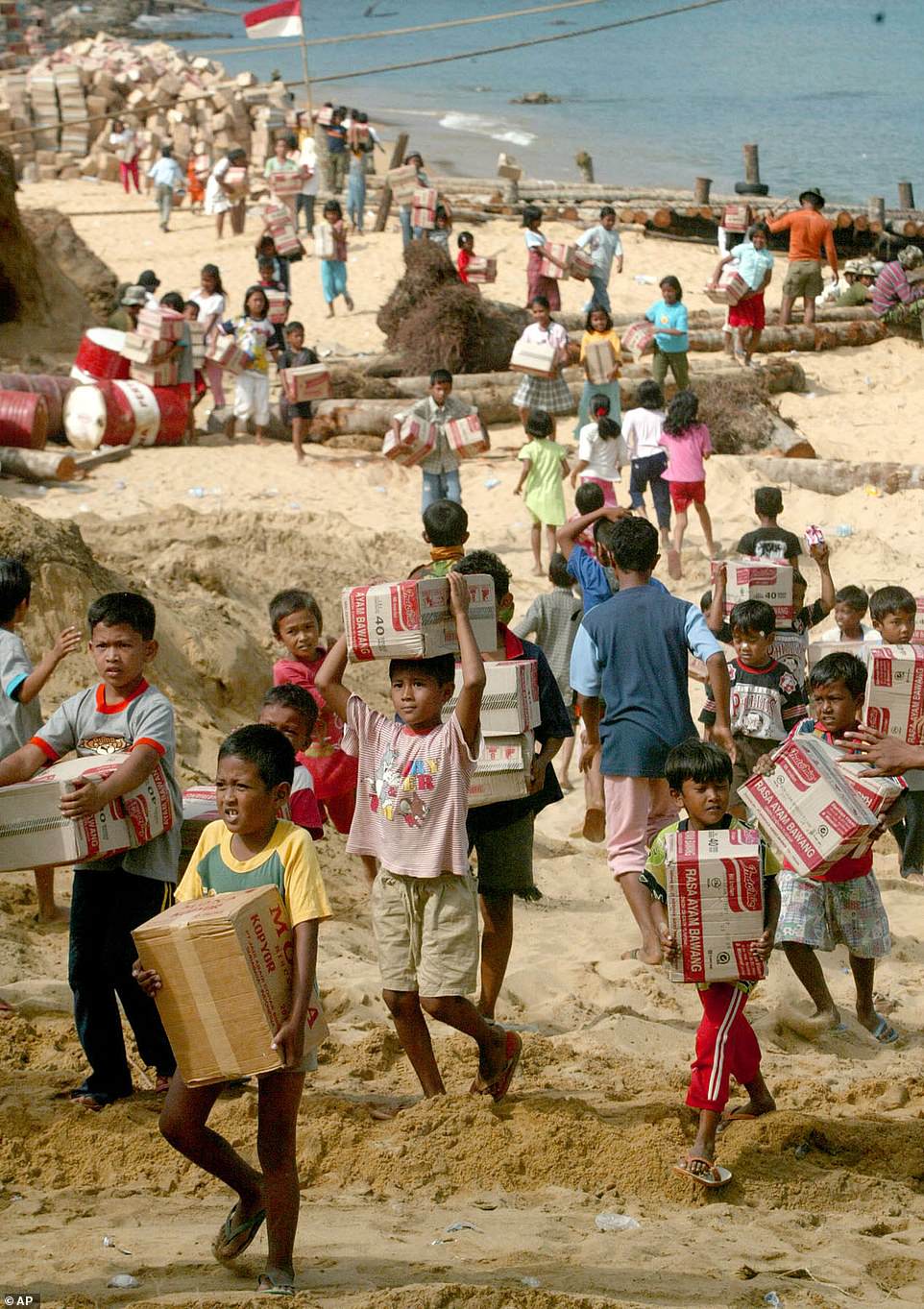 Children from Aceh carry boxes of food aid distributed by the Indonesian Navy in the tsunami-ravaged town of Calang, Aceh province, Saturday, January 22, 2005