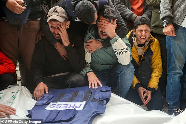 Mourners attend the funeral of members of the press killed in an Israeli attack