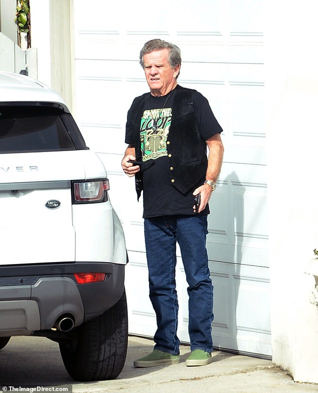 Patrick was rocking a classic pair of Ray-Bans, a pair of dark jeans, a black leather vest to complete the look, and what appears to be a pair of green Vans Slip-Ons.