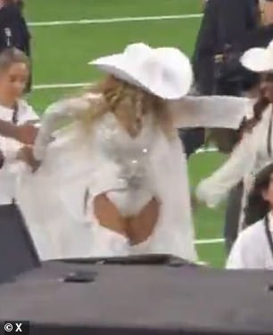 The celebrity was so overwhelmed with emotions that she had difficulty putting on her white coat after leaving the football field