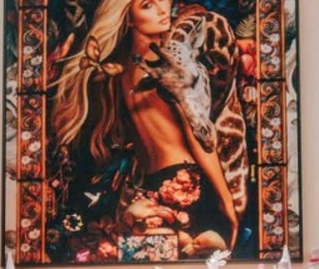 The photos showed an interesting detail that Paris may not have wanted to show off. Above her fireplace hung a bizarre portrait of the blonde pin-up daughter of RHOBH star Kathy Hilton. The painting shows Hilton with a giraffe nuzzling her, while a butterfly sits to the side