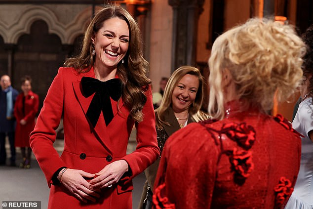 The Princess of Wales, pictured wearing an Alexander McQueen coat during the 'Together At Christmas' carol service and chatting with singer Paloma Faith, right.