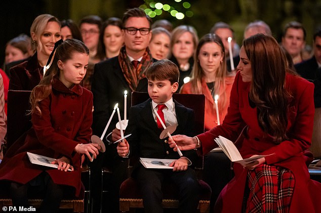 Princess Charlotte, Prince Louis and the Princess of Wales hold candles as they sit on a bench at Westminster Abbey during the service.