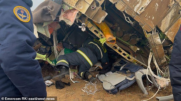 The image shows rescuers crawling towards the crashed plane in search of survivors.