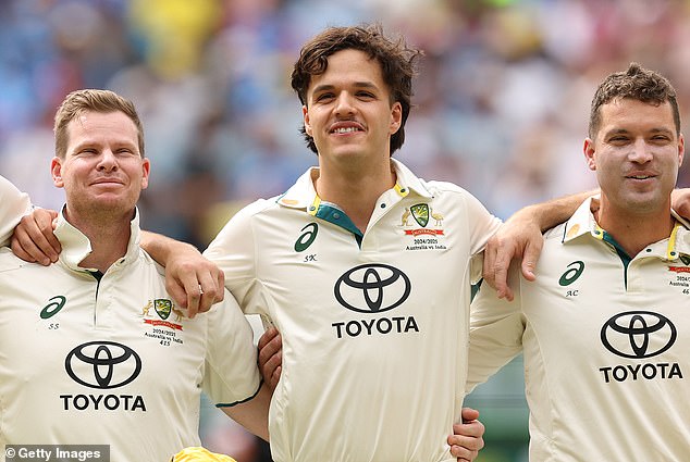 Pictured: Konstas (centre) is flanked by teammates Steve Smith (left) and Alex Carey before the start of the game on Thursday.