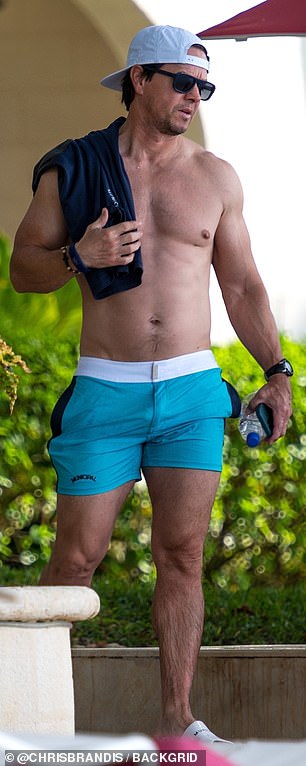 Mark's chiseled chest, washboard abs and muscular arms were exposed as the father-of-four wore only blue shorts.