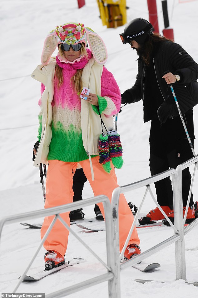 Heidi donned a pastel cable-knit sweater paired with vibrant orange ski pants, but it was her quirky hat, complete with long bunny ears, that stole the show.