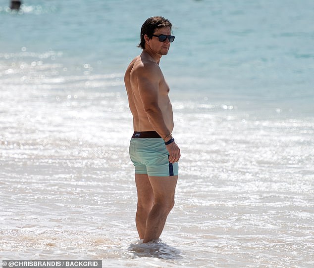 The actor, 53, known for his strict exercise regime, wore a blue swimsuit without a shirt as he sunbathed.