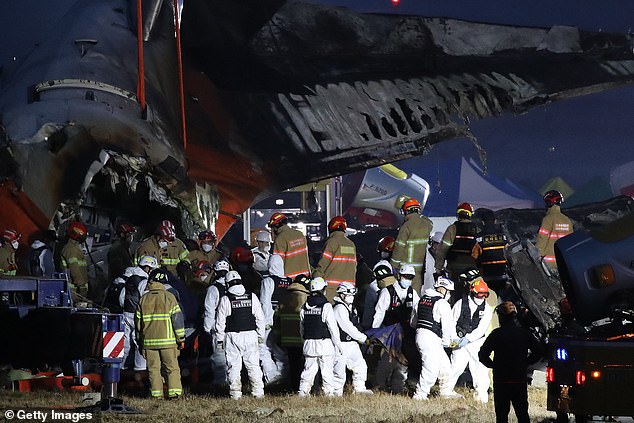 Firefighters remove the body of a passenger from the wreckage of a passenger plane at Muan International Airport on December 29, 2024.