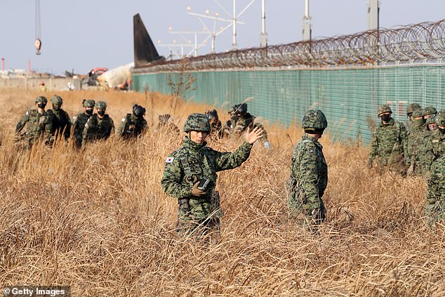 South Korean soldiers inspect near the wreckage of a passenger plane at Muan International Airport