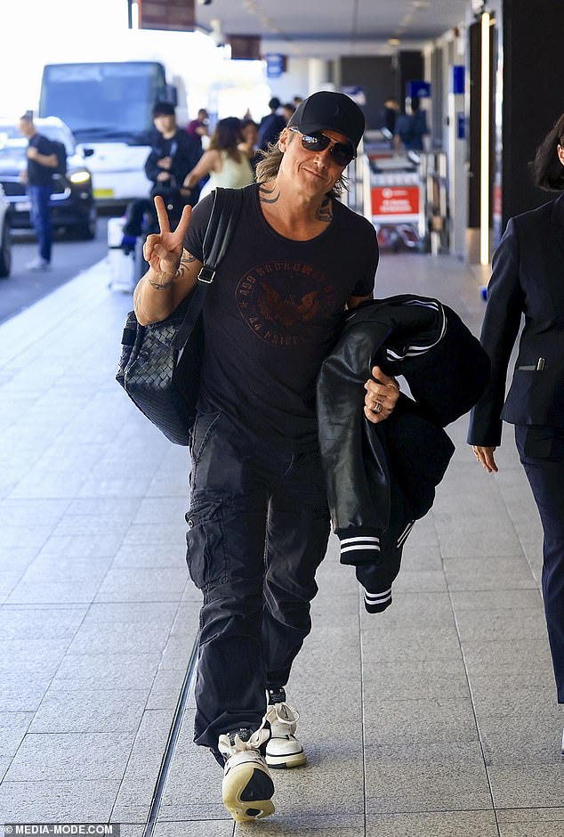 Meanwhile, Keith kept things casual as he walked through the Kingsford Smith Airport terminal with a backpack over his shoulder.