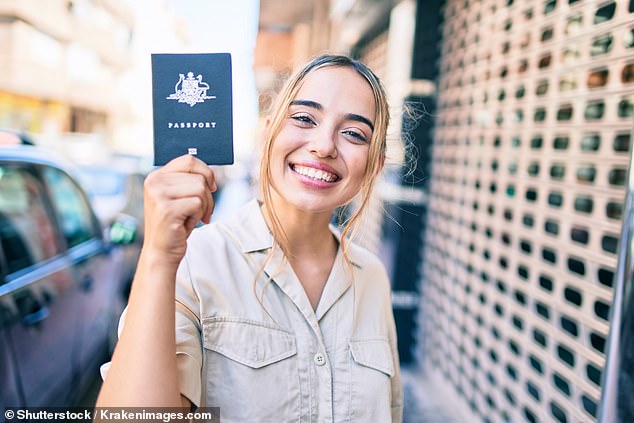 In the photo, a young woman holds her Australian passport, which is now the most expensive in the world.