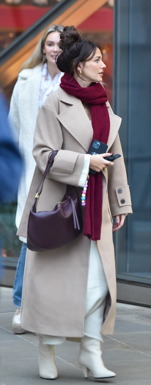 Michelle hid her baby bump earlier this month by wearing a long beige coat and a scarf, completing her look with white boots and a maroon bag.