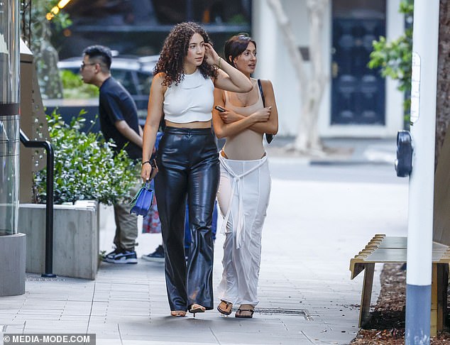 She walked alongside a friend who echoed her fashion-forward look in a pair of high-waisted leather pants and a white crop top.