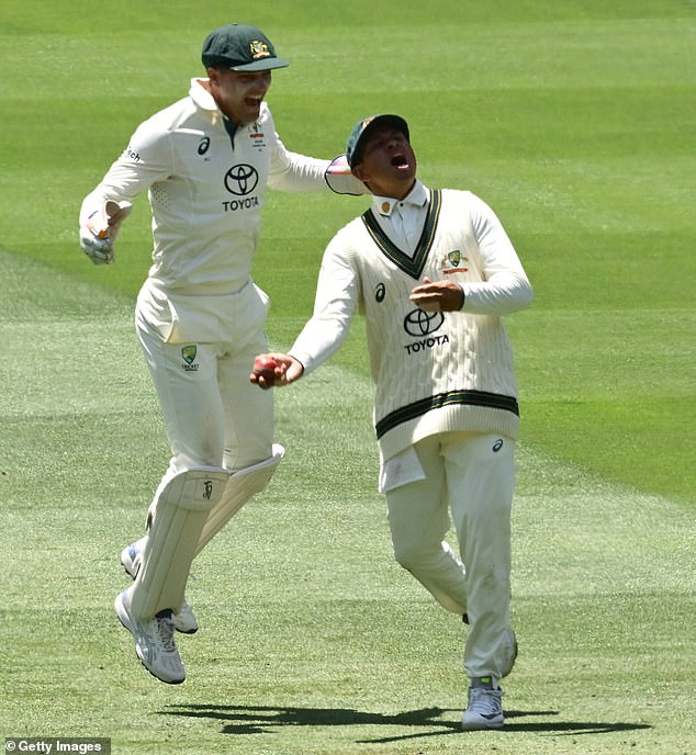 Usman Khawaja (front) and Alex Carey (back) celebrate the dismissal of Virat Kohli