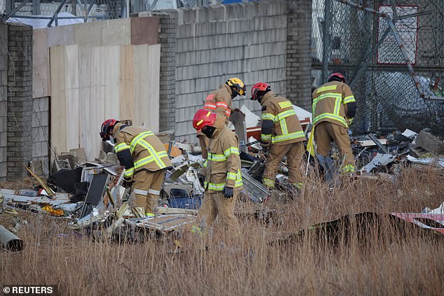 Rescuers work near the wreckage of the Jeju Air plane that went off the runway and crashed at Muan International Airport