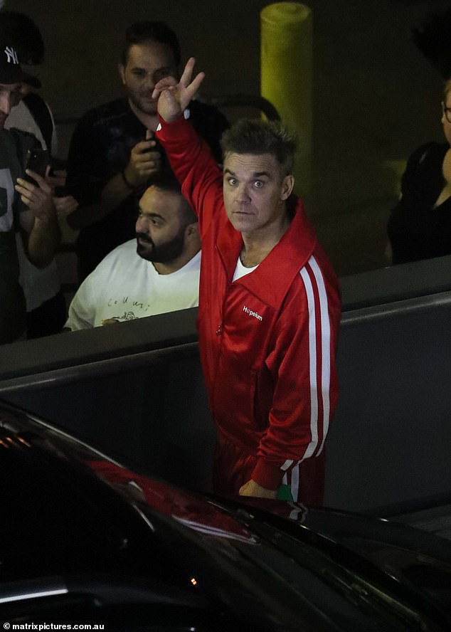 The Better Man star dressed comfortably in a red tracksuit paired with a white t-shirt.