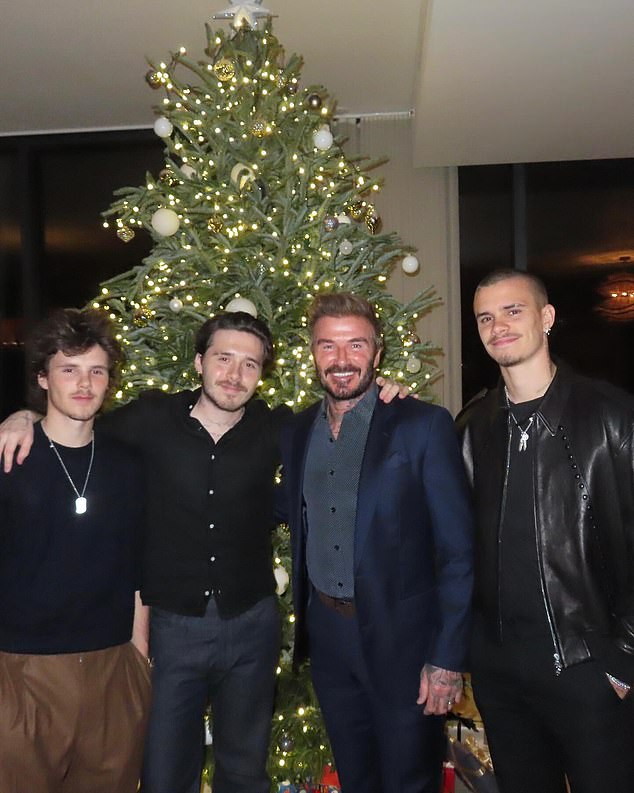 David Beckham pictured with his sons Cruz, Romeo and Brooklyn in front of the Christmas tree - the family celebrated Christmas abroad this year in Miami