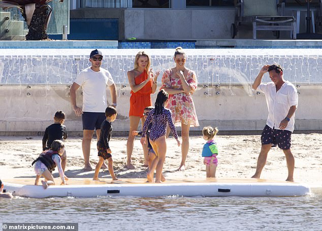 Karl's wife, Jasmine (center right), watched their four-year-old daughter Harper play in the sand.